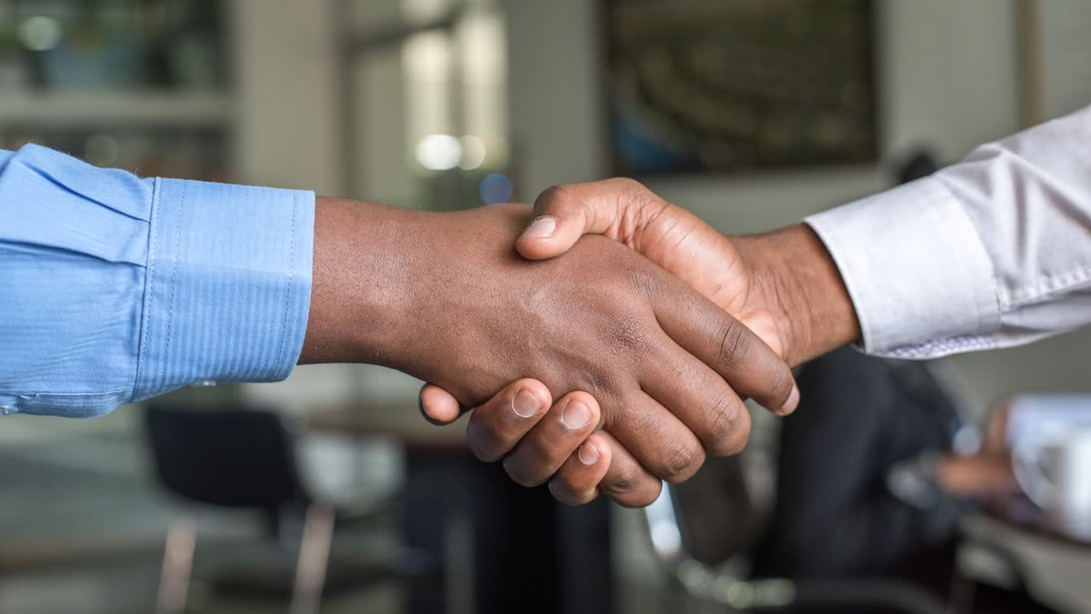 Business handshake marking a calm CRM migration without losing leads